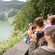 Tourists at a lookout point take pictures of a scenic lake